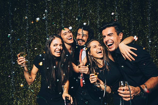 Friends celebrating at a party with champagne and confetti